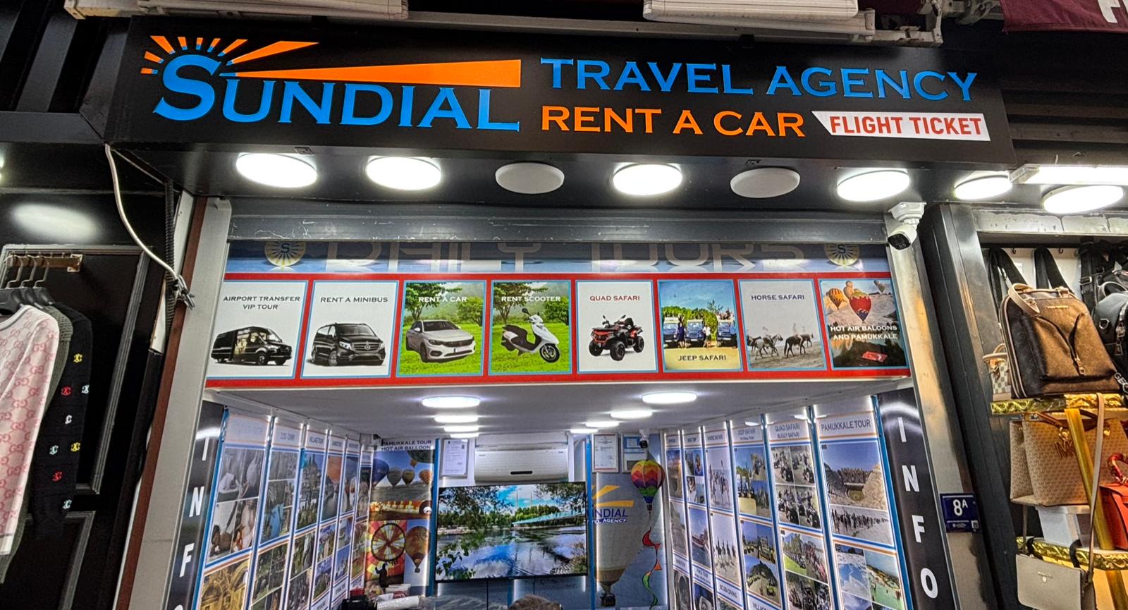 Sundial Travel Agency illuminated logo and daily tours signboard